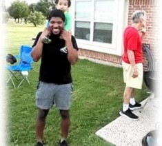 A young man smiling in the backyard