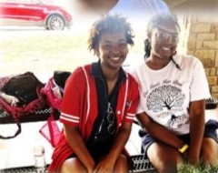 Two young women smiling on a bench