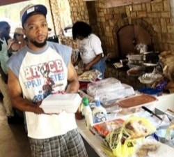 A young man with a plate at the food table