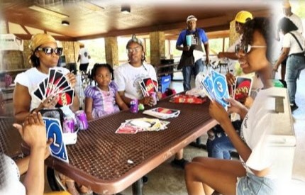 Family playing cards at a picnic table