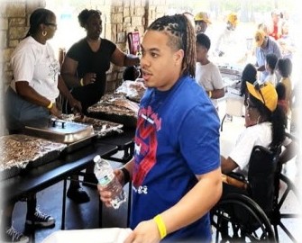 A young man in a blue shirt at the food table