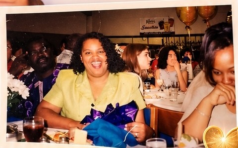 Karen at a celebration, smiling with a gift at a banquet table