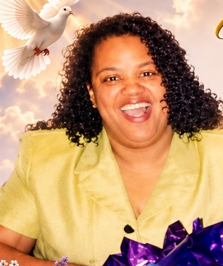 Karen smiling broadly, holding a gift wrapped in purple
