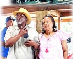 Norman and Brenda Hill outdoors, Norman in a straw hat