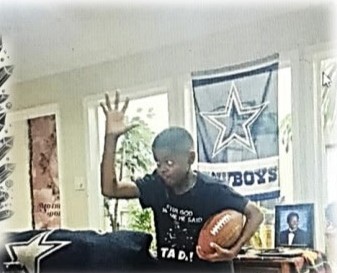 A young fan celebrating with a football, hand raised
