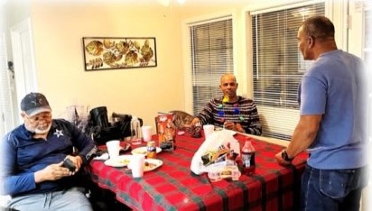 Family gathered around a table with a red plaid tablecloth